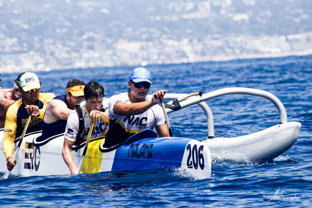 5 men paddling outrigger canoe